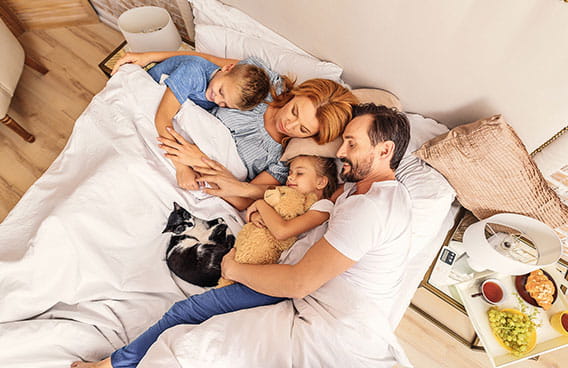 Family in bed with pet